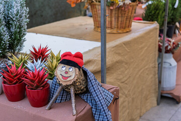 Handcrafted wooden Tio de Nadal Christmas logs with traditional red hats at a festive market stall.
