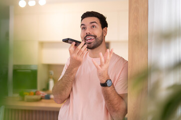 Man sending voice message using smartphone at home