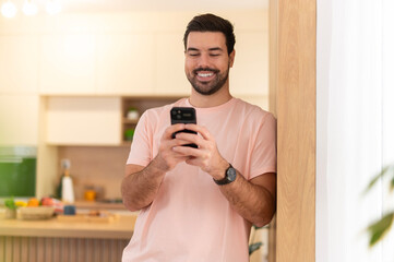 Smiling man using smartphone browsing social media app