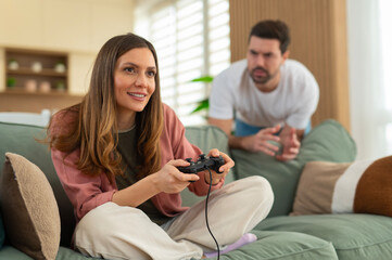 Woman playing video game with man feeling frustrated