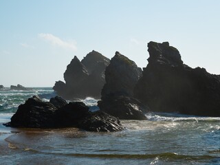 Sunny Day at Donnant Beach with People Relaxing on Golden Sand, Atlantic Ocean Waves Crashing Against the Shoreline and Grassy Coastal Cliffs in Belle-Ile-en-Mer, Brittany, France