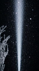 Fototapeta premium Beam of bright white light in the darkness, with numerous sparkling specks, suggests magic, ethereal quality, and hope, suitable for fantasy theme