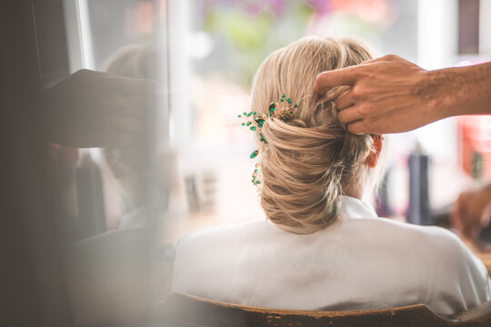 Bride's hair being styled with a decorative hairpiece before the wedding ceremony