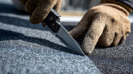 Ultra-realistic close-up of asphalt shingle edges being trimmed neatly with a utility knife by gloved hands