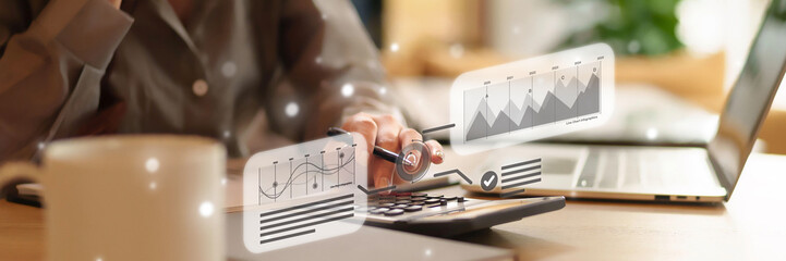 Adult hand calculating financial metrics with virtual data visualization charts for strategic business planning