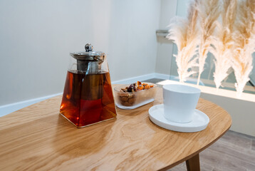Artisan Glass Teapot With Amber Infusion Closeup On Wooden Table White Cup And Snack Bowl, Natural Light Highlighting Clarity Of Brew And Ritual Of Mindful Brewing, Serene Modern Aesthetic