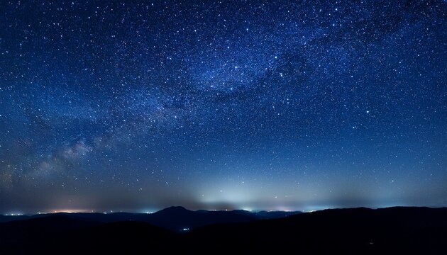 dark blue to black midnight sky speckled with stars illuminating the night
