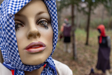 Vecchi paurosi manichini usati e rovinati con vestiti vintage e colorati lasciati nel bosco...