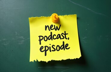 Yellow sticky note on green chalkboard announces a new podcast episode. The simple message uses bold black marker text. Notification for upcoming audio content release.