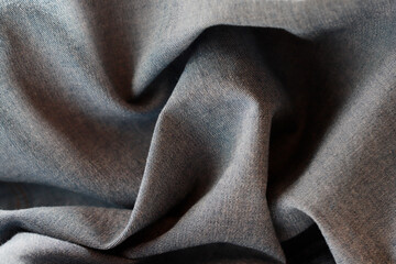 Dramatic lighting on denim fabric. Background, wallpaper.