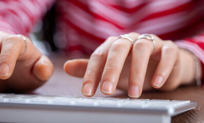 woman typing on  keyboard at office