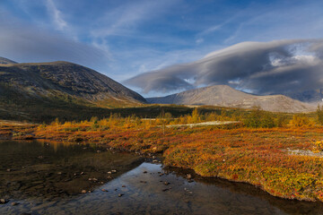 Autumn Mountain Landscape With Lake, Golden Foliage, And Calm Sky Above Rolling Hills