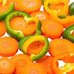 A vibrant close-up of sliced carrots and colorful bell pepper rings against a dark background.