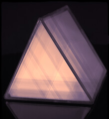 A triangular prism shape abstract with glow effect on a black background