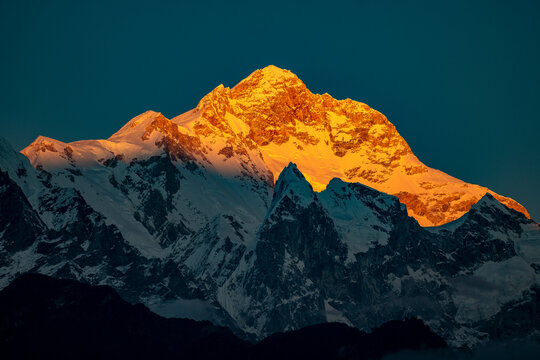 Golden alpenglow illuminating the summit of Mount Manaslu (8,163 meters), the eighth-highest mountain in the world, photographed from Timang village on the Annapurna Circuit in Nepal. Dramatic Himalay