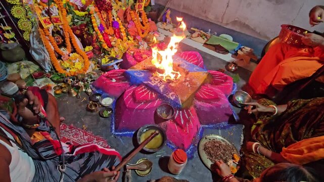Flames rise from a decorated havan kund as priests conduct a sacred Hindu ritual, highlighting spirituality, faith, and cultural heritage.