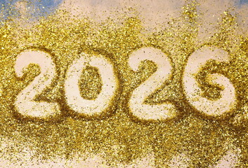 A large number of sequins with the numbers of the year "2026" written in gold. The color scheme of sequins and gold gives the image a festive mood.
