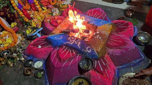 Flames rise from a decorated havan kund as priests conduct a sacred Hindu ritual, highlighting spirituality, faith, and cultural heritage.