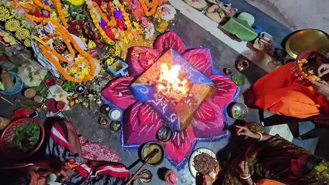 Flames rise from a decorated havan kund as priests conduct a sacred Hindu ritual, highlighting spirituality, faith, and cultural heritage.