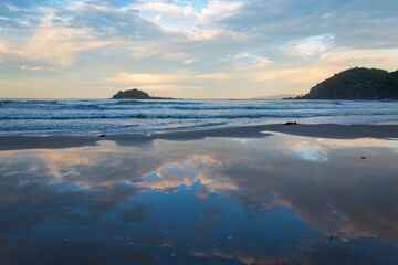 reflexo do c&eacute;u e o p&ocirc;r-do-sol na Praia Palmas do Arvoredo cidade de Governador Celso Ramos Santa Catarina Brasil regi&atilde;o da Grande Florianopolis 