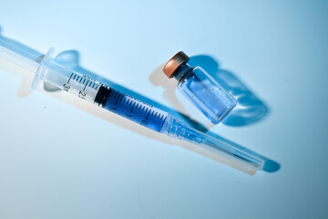 Close up of Single use Syringe Next to Glass Vial