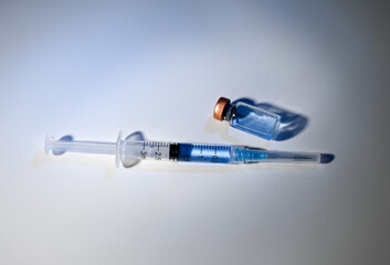 Close up of Single use Syringe Next to Glass Vial