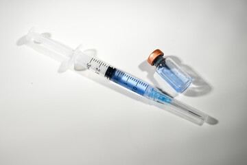 Close up of Single use Syringe Next to Glass Vial