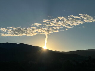 Contrail and clouds at dawn over Santa Fe, NM