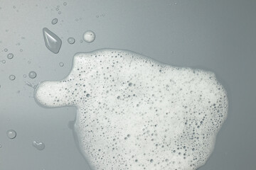 White foam on a gray background. Cleanliness concept.