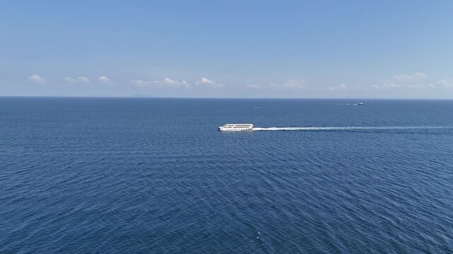 Side view of a ship sailing on the sea, showcasing the vessel&rsquo;s structure against a calm marine background with natural light and open horizon