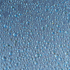 Abstract background texture of fresh blue water rain drops on wet glass or metal surface