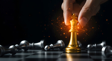 Golden chess king held by hand over fallen silver pieces