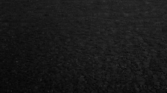 Dark static noise background with horizontal interference and analog distortion, cinematic glitch texture for transitions and moody video effects