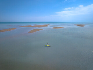 a surfer with a board walks on the water