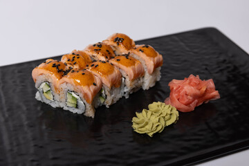 Salmon skin sushi roll served on a black stone, top view