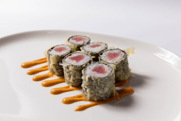 Sushi rolls with crab filling served on a white plate with wasabi, pickled ginger