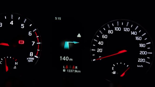 Illuminated car dashboard showing speedometer, tachometer, fuel gauge, and navigation display highlights modern vehicle technology during night driving.