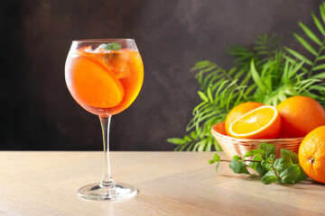 Refreshing spritzer cocktail with mint and oranges on wooden table