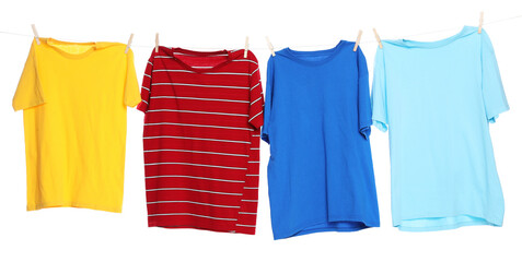 Different clothes drying while hanging on clothesline against white background