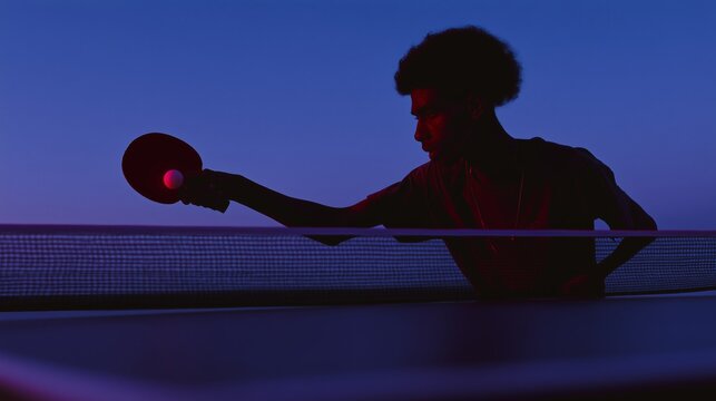 Hombre afro sacando en partida de ping pong con iluminaci&oacute;n azul, Primer plano de jugador de tenis de mesa con raqueta y pelota, Fotograf&iacute;a conceptual para art&iacute;culo de psicolog&iacute;a del deporte