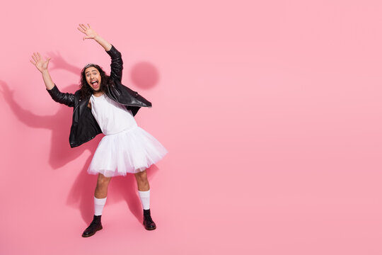 Joyful nonbinary LGBT man in tutu and leather jacket poses playfully on a pink backdrop, celebrating bold fashion and gender expression - Powered by Adobe