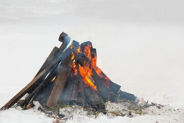 A cosy campfire event, with crackling flames and a warm glow contrasting with the serene white snow, creating a tranquil winter atmosphere.