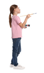 Child with brush and colorful paints painting something on white background