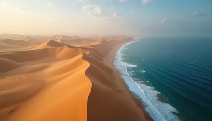 Vast desert dunes meet calm ocean waves at sunrise. Golden sand formations stretch along the coast under a soft sky. This natural wonder offers a breathtaking contrast of land and sea.