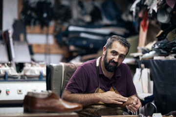 Cobbler at work in a busy leather workshop, crafting shoes with focus and care