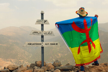 A Moroccan man holding the Amazigh flag in AMSAFRANE summit in Azilal Morocco. The photo was taken in August 20th, 2020.
