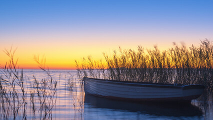 Old boat at sunrise on lake Balaton Hungary