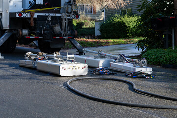 Wireless communications cell site upgrade to 5G technology, panel antennas on street with coaxial cable, back of industrial work truck, residential neighborhood
