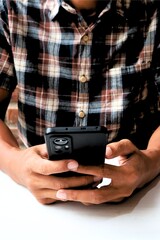 a man holding a cell phone in front of a glass jar filled with coins