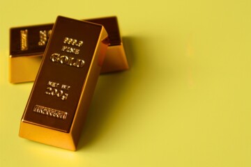 Stack of gold bars on yellow background